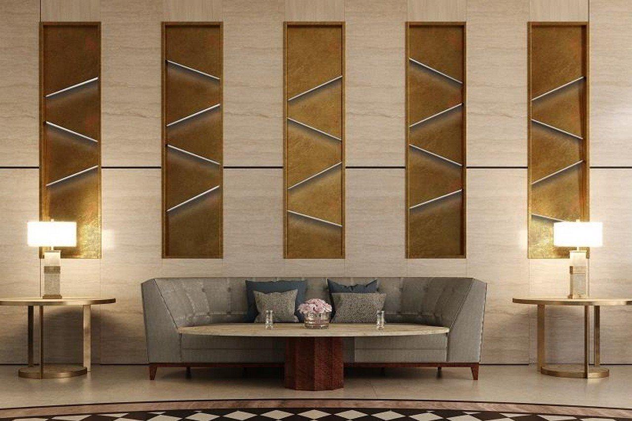 Grand Swiss-Belhotel Waterfront Seef Sanabis Exterior photo The photo showcases a stylish interior space featuring a modern living area. In the center, there's a gray sofa with decorative cushions, positioned in front of a round wooden coffee table. Behind the sofa, the wall is adorned with three vertical pan